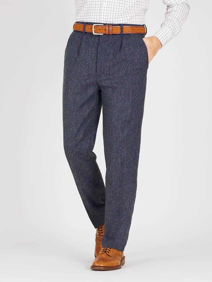 Das Model trägt eine blaue Hose aus feinem Donegal-Tweed.