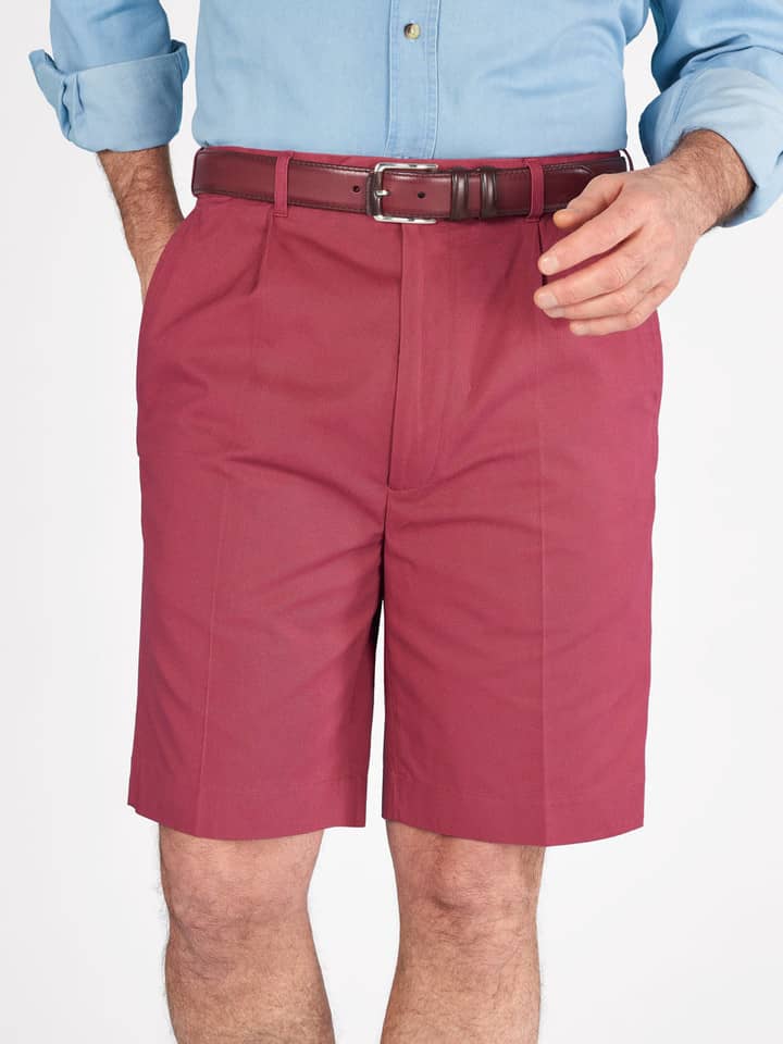Das Model trägt eine rote Plisseeshorts aus Baumwolle für Herren.