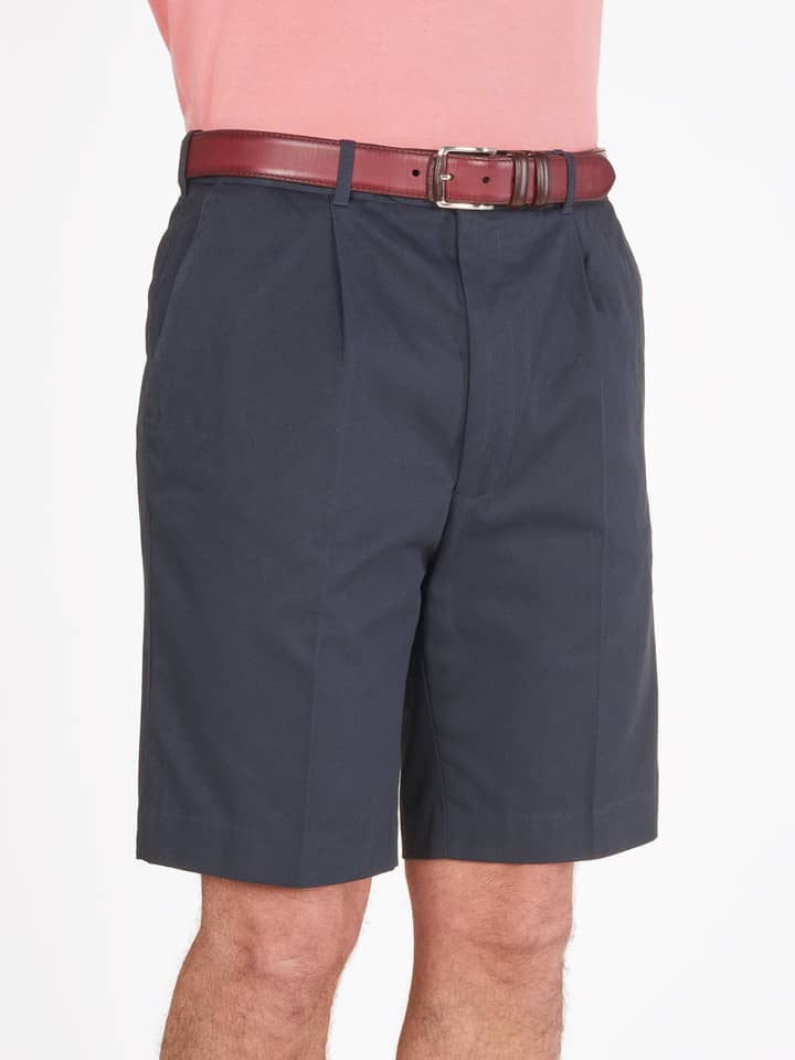 Das Model trägt eine marineblaue Plisseeshorts aus Baumwolle für Herren.