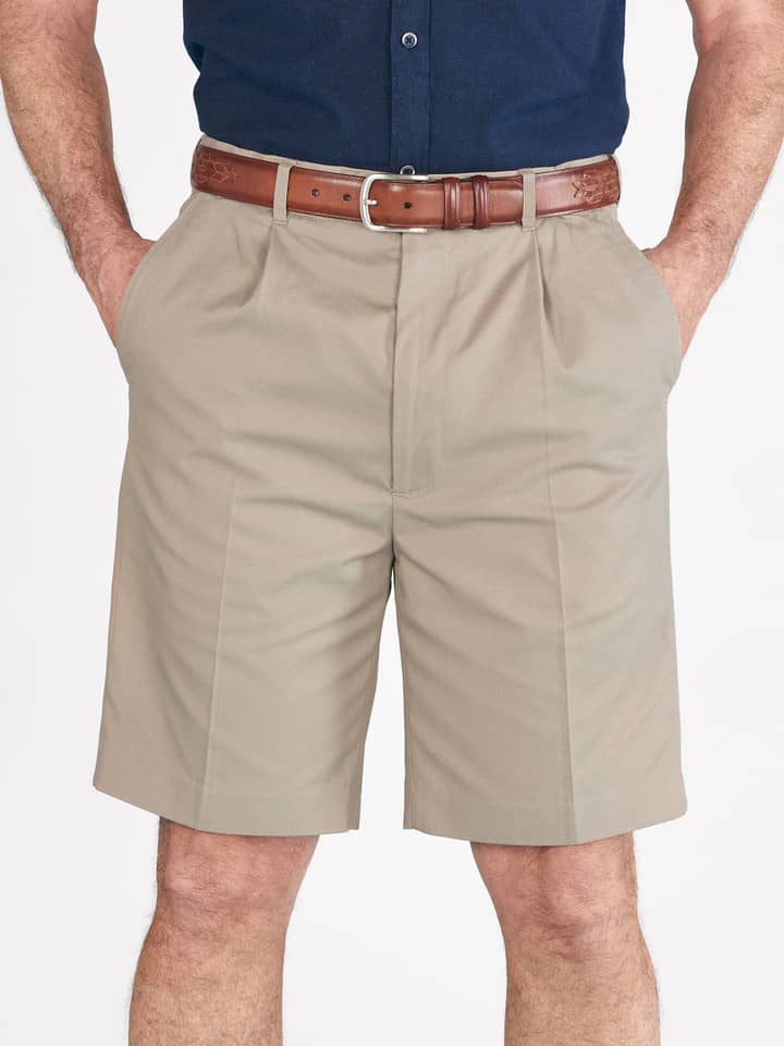 Das Model trägt eine sandbraune Plisseeshorts aus Baumwolle für Herren.
