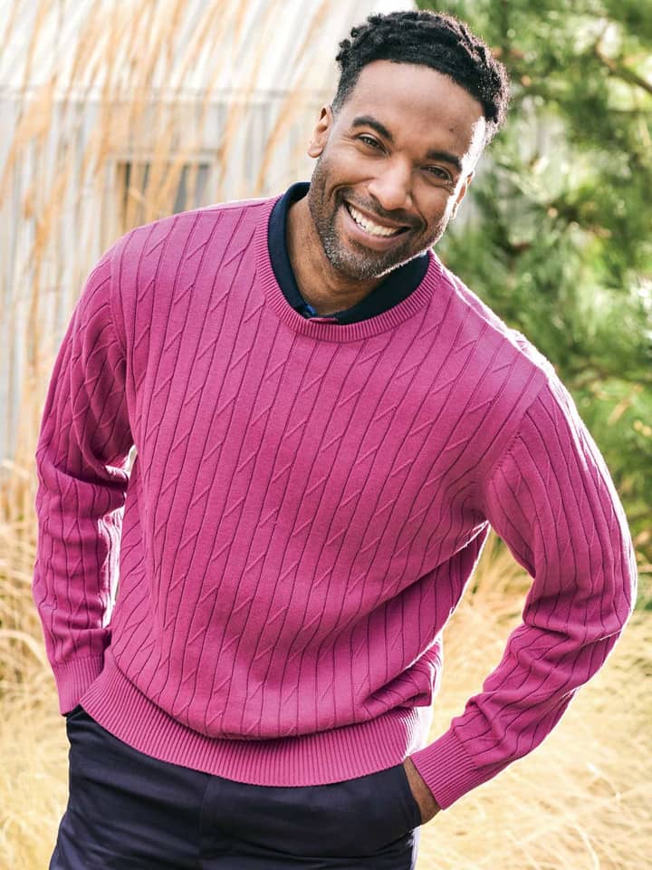 Model trägt einen magentarosa Baumwollpullover mit Rundhalsausschnitt